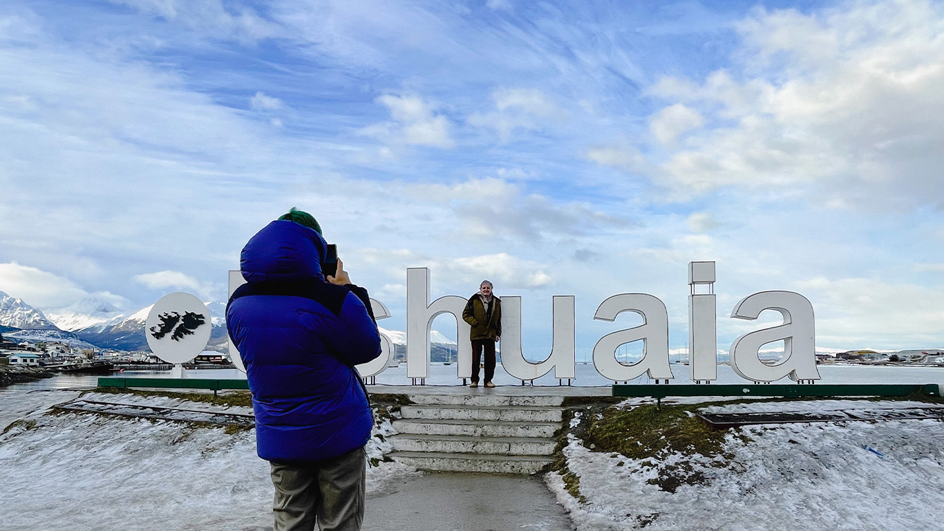 Turista tomando foto en cartel Ushuaia